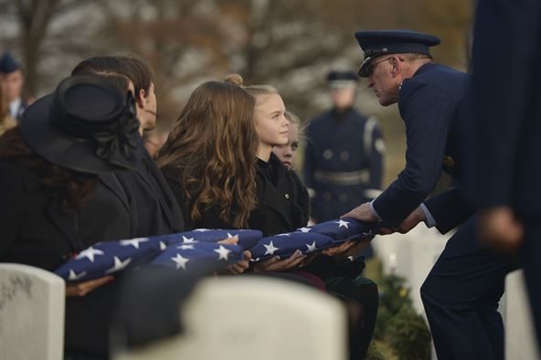Maj. Gen. Scott Vander Hamm, the Air Force assistant deputy chief of staff of operations, presents a flag to Annalise during the interment for her father, Maj. Troy Gilbert, at Arlington National Cemetery, Va., Dec. 19, 2016. He is survived by his mother and father, Kaye and retired Senior Master Sgt. Ron Gilbert; sister, Rhonda Jimmerson; wife, Ginger Gilbert Ravella; sons, Boston and Greyson; and daughters, Isabella, Aspen and Annalise. (U.S. Air Force photo/ Tech. Sgt. Joshua DeMotts)